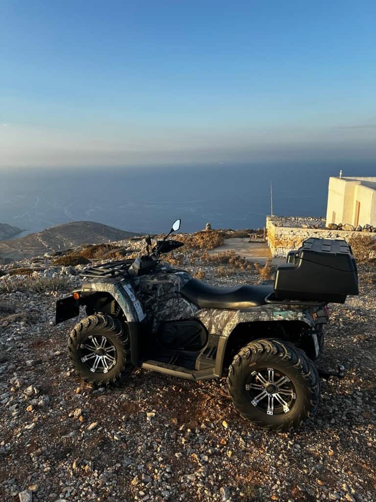 Un quad CFMOTO aparcado en la carretera del acantilado sobre el mar en Folégandros